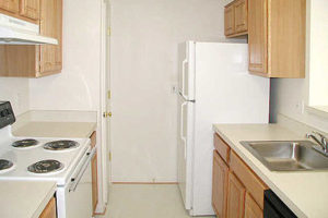 Kitchen with pantry, fridge, electric stove top oven, sink and cabinets