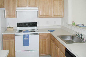 Kitchen with electric stove top oven, sink and cabinets