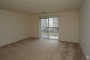 Carpeted living area with sliding glass doors leading to balcony