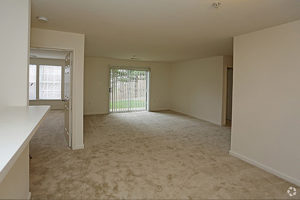 Carpeted living area showing view into living room and bedroom