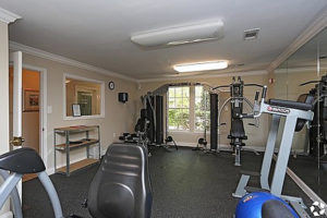 Gym with several workout machines with window on back wall